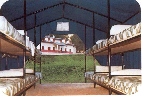 a group of bunk beds with a view of a house at El Chate Tiendas in Sarvisé