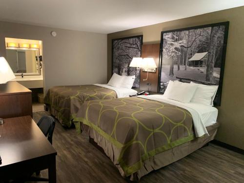 a hotel room with two beds and a desk at Super 8 by Wyndham Cookeville, TN in Cookeville