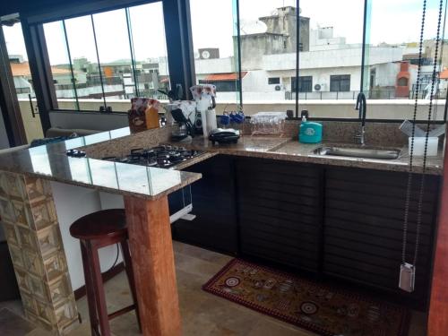 a kitchen with a counter with a sink and a stove at Cobertura em cabo frio in Cabo Frio