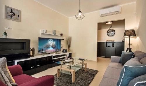 a living room with a couch and a tv at Apartamento Amarelo in Conceição