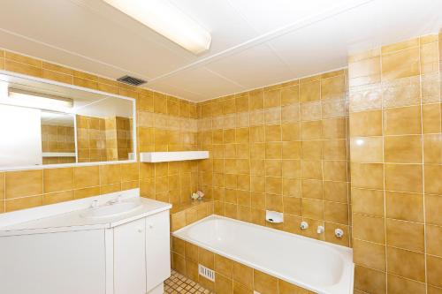 a bathroom with a tub and a sink and a mirror at Sandbar unit 402 in Forster