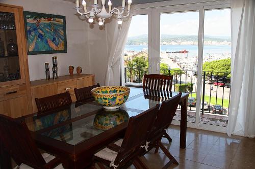 uma sala de jantar com uma mesa de vidro e uma grande janela em VISTAS PRIVILEGIADAS em Palamós