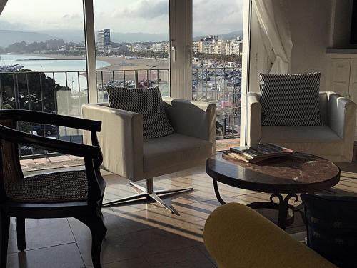 a living room with chairs and a table and a large window at VISTAS PRIVILEGIADAS in Palamós