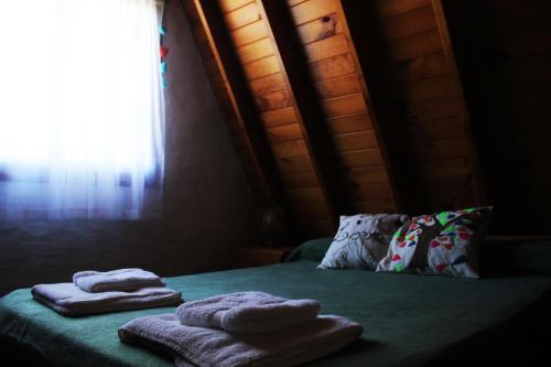 2 toallas en una cama en una habitación con ventana en Cabañas Alpinos en Villa Gesell