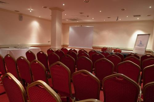a conference room with red chairs and a table at Adelphi Hotel in Liverpool