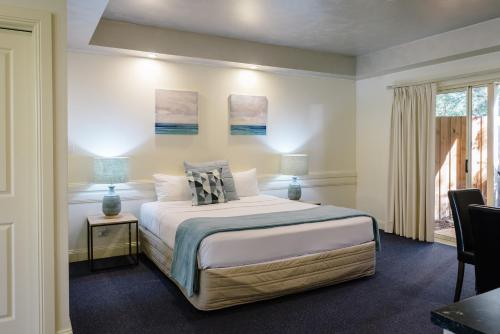 a bedroom with a large bed and a window at Fairways Resort in Rosebud