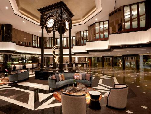 a lobby with a clock in the middle of a building at Orchard Hotel Singapore in Singapore