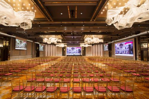 a large room with a large stage with red chairs at Orchard Hotel Singapore in Singapore