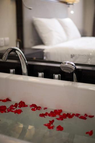 a sink with red rose petals in it at CityHouse - Atelier Apartment & Hotel in Ho Chi Minh City