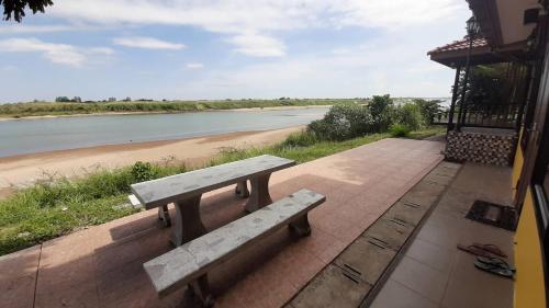 a wooden bench sitting next to a river at Mekong Tarawadee Villa in Tha Bo
