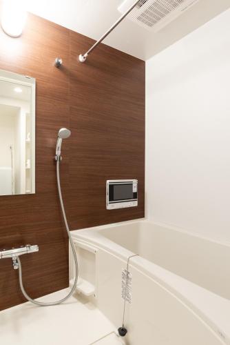 a bathroom with a bathtub and a mirror at Dash Living Higashi Azabu in Tokyo