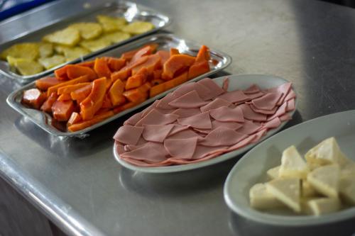 a counter with plates of food and trays of food at Hotel & Resort Villa del Sol in Tumaco