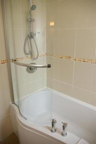 a bathroom with a shower and a tub with a sink at The Maid's House in Lanark