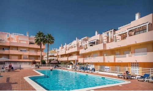 a swimming pool in front of a large building at Apartamento Amarelo in Conceição