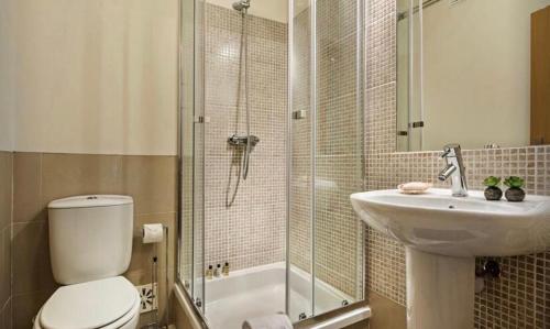 a bathroom with a toilet and a sink and a shower at Apartamento Amarelo in Conceição