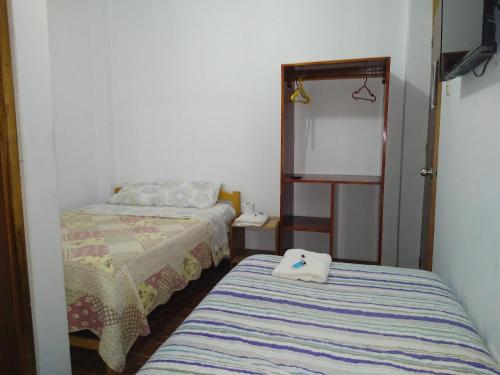 a small room with two beds and a mirror at BACHÍG Hospedaje in Moyobamba