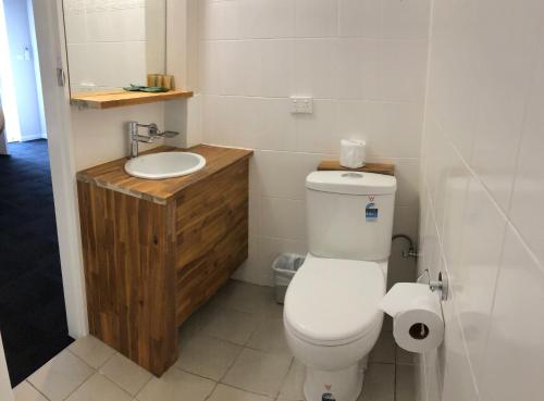 Łazienka z białą toaletą i umywalką w obiekcie Nowra Motor Inn w mieście Nowra