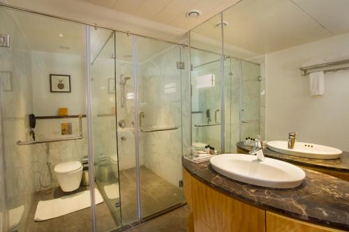 a bathroom with a shower and a sink and a toilet at Fountain Tree by TGI in Bangalore