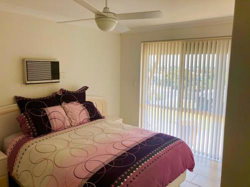 a bedroom with a bed and a ceiling fan at Relaxed Ocean View in Mandurah