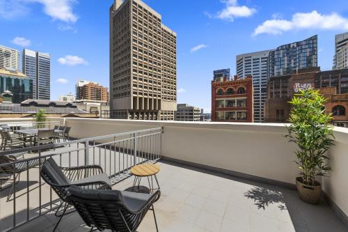 a balcony with chairs and a view of the city at YEHS Hotel Sydney QVB in Sydney