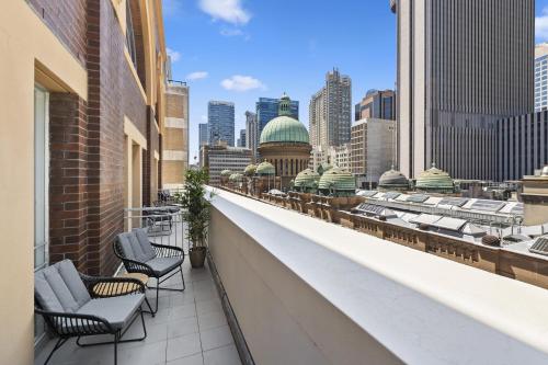 a balcony with chairs and a view of the city at YEHS Hotel Sydney QVB in Sydney