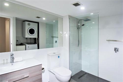 uma casa de banho com um WC e uma cabina de duche em vidro. em Grande Florida Beachside Resort em Gold Coast