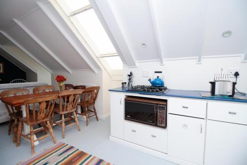 a kitchen with white cabinets and a table with chairs at Beside Still Waters in Wilderness