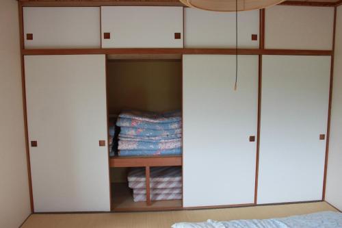 einen Schrank mit weißen Schränken in einem Schlafzimmer in der Unterkunft Farm Inn Tsurui in Tsurui