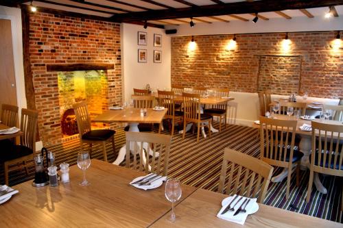 a restaurant with tables and chairs and a brick wall at The North Hill Hotel in Colchester