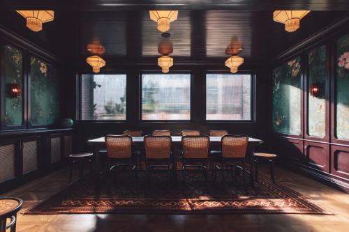 Cette chambre comprend une table, des chaises et des fenêtres. dans l'établissement The Chow Kit - an Ormond Hotel, à Kuala Lumpur