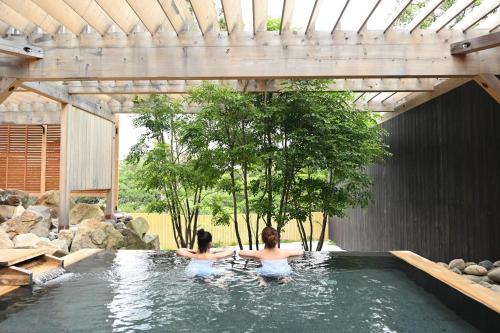 two women are sitting in a pool of water at Grampus Sea in Shirahama