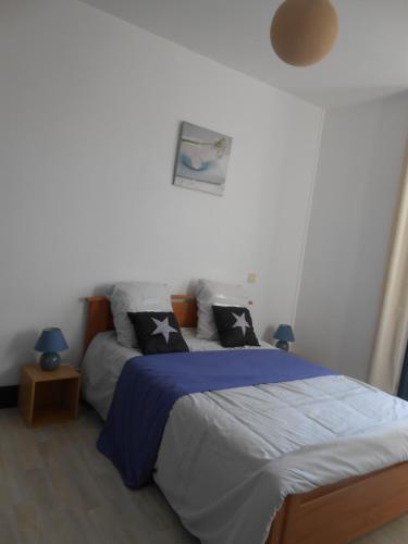 une chambre avec un lit avec des draps et des oreillers bleus dans l'établissement Maison Ancienne Rénovée Du XIXème à Partir de 1 à 10 personnes plus 2 bébés, à Saint-Aignan