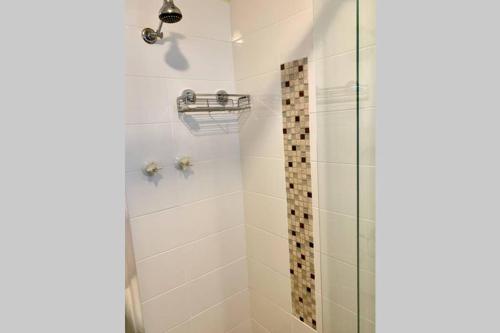 ein Bad mit einer Dusche und einer Glastür in der Unterkunft Leeward 'tranquil beachfront' in Kingscote
