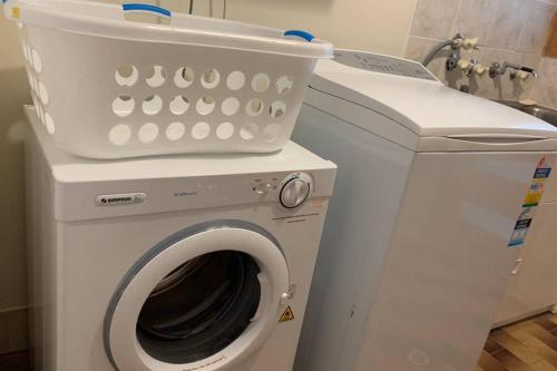 a washing machine with a bucket on top of it at Leeward 'tranquil beachfront' in Kingscote