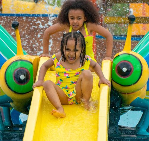 two girls riding on a slide at a water park at Kuriftu Resort & Spa Bishoftu in Debre Zeyit