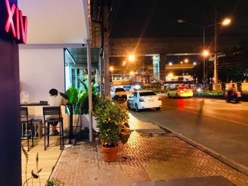 a man sitting at a table on a street at night at Dragon XIV in Bangkok