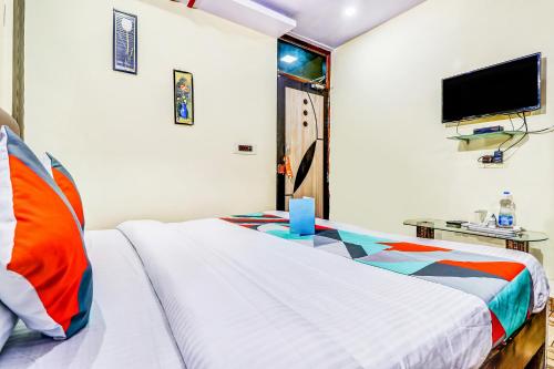 a bedroom with a bed and a tv on the wall at FabHotel Gazal Residency Mahanagar in Lucknow