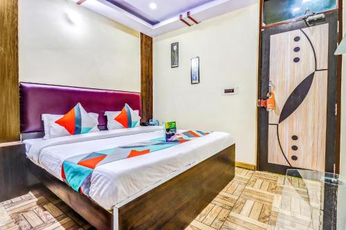 a bedroom with a bed with a purple headboard at FabHotel Gazal Residency Mahanagar in Lucknow