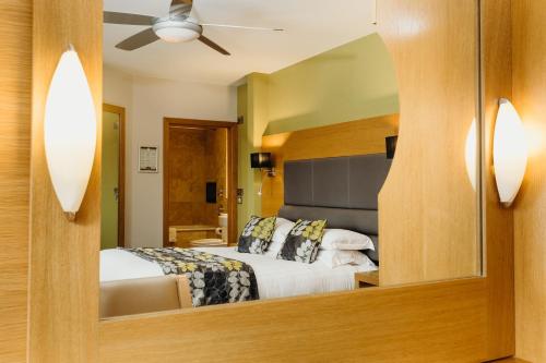 a bedroom with a bed and a mirror at Crown Spa Hotel Scarborough by Compass Hospitality in Scarborough