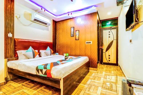 a bedroom with a bed and a door to a room at FabHotel Gazal Residency Mahanagar in Lucknow