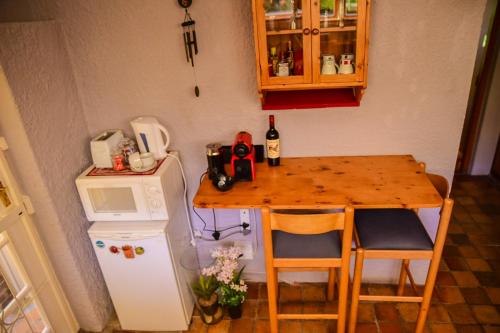 a small kitchen with a table and a small refrigerator at On Pinewood Guest House in Cape Town