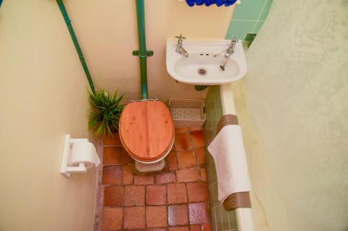 a bathroom with a toilet and a sink at On Pinewood Guest House in Cape Town