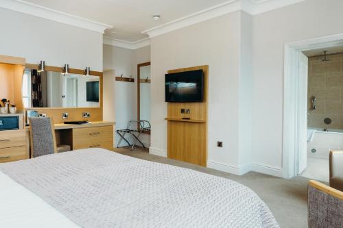 a bedroom with a white bed and a bathroom at Crown Spa Hotel Scarborough by Compass Hospitality in Scarborough