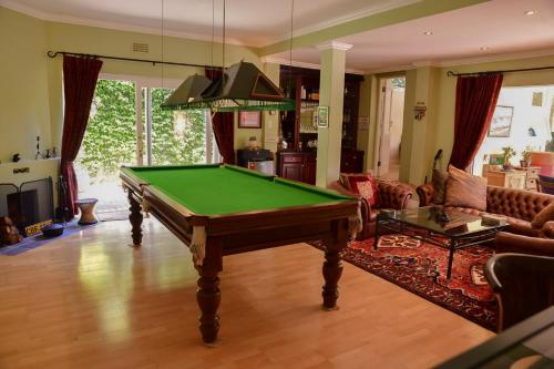 a living room with a pool table in it at On Pinewood Guest House in Cape Town