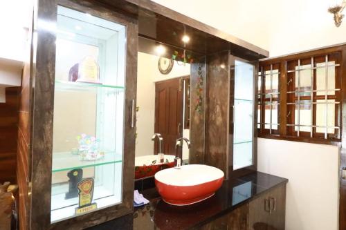 a bathroom with a red sink and a mirror at Eagle Fly Homestay in Chikmagalūr