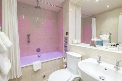 a bathroom with a tub and a toilet and a sink at Crown Spa Hotel Scarborough by Compass Hospitality in Scarborough