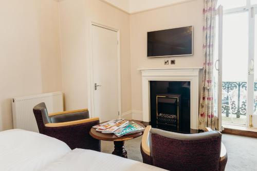 a hotel room with a bed and a fireplace at Crown Spa Hotel Scarborough by Compass Hospitality in Scarborough