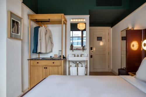 a bedroom with a white bed and a sink at The Chow Kit - an Ormond Hotel in Kuala Lumpur