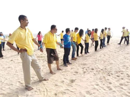 a group of people standing in a line on the beach at The Sunset Beach Resort - Koh Kho Khao in Ko Kho Khao