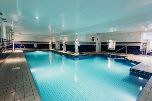 a large swimming pool with blue water in a building at Crown Spa Hotel Scarborough by Compass Hospitality in Scarborough